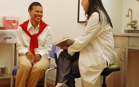 Young female doctor talking with female patient