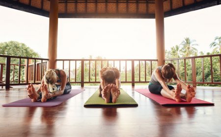 three-women-practicing-paschimottanasana-pose-at-y-P7F46KA.jpg